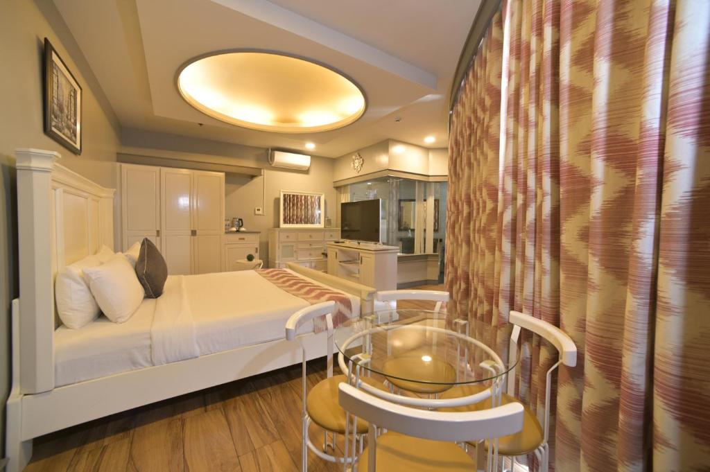 碧瑶百丽宫套房酒店 的卧室配有一张床和一张桌子及椅子
