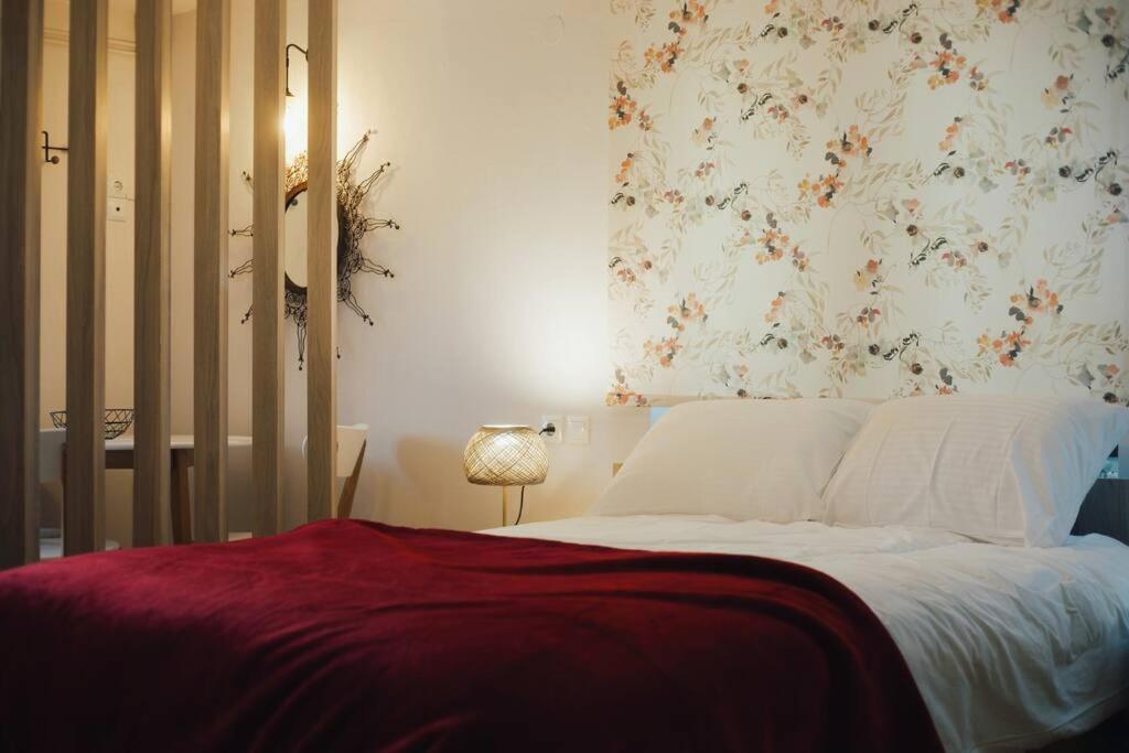 卡尔派尼西翁Το Σπίτι Της Ευτυχίας στούντιο的一间卧室配有一张带花卉壁纸的床