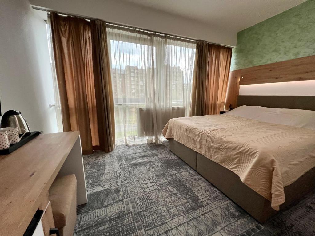 萨拉热窝Hotel Brkic的酒店客房设有一张床和一个大窗户