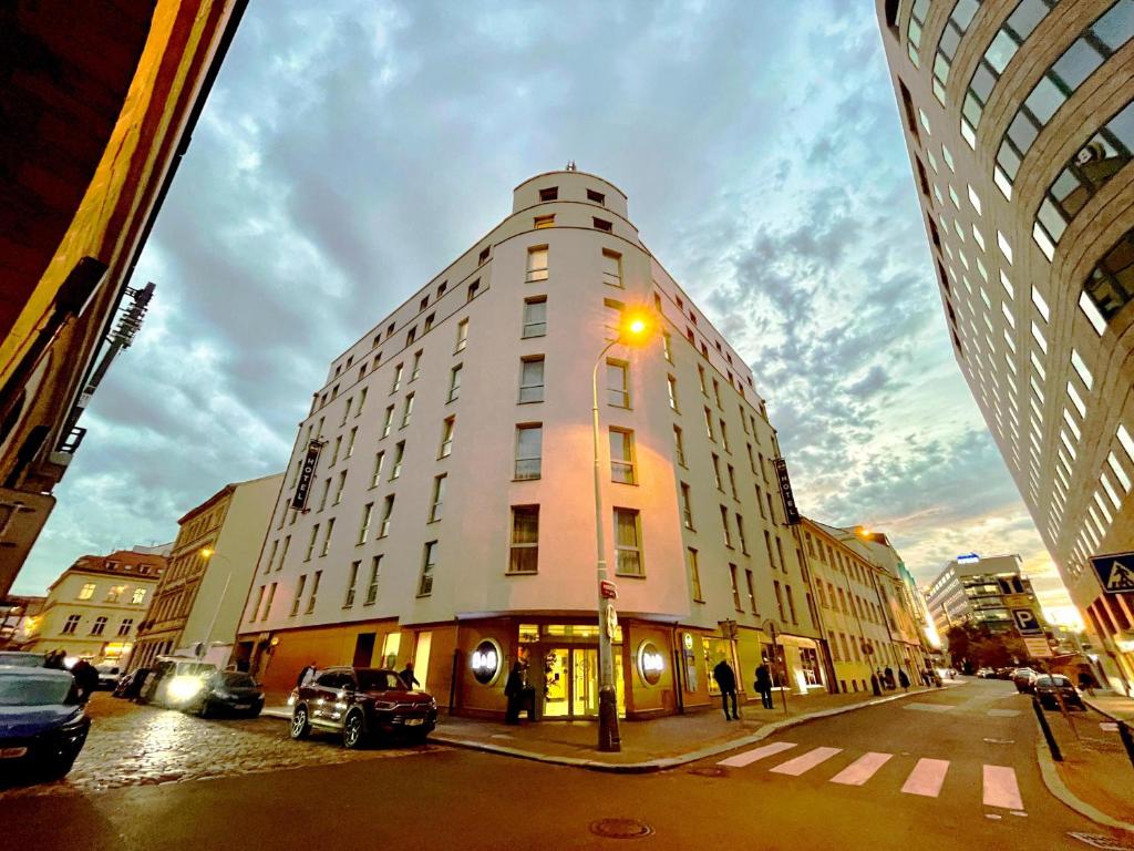 布拉格布拉格市住宿加早餐酒店的街道上高大的建筑,有街灯