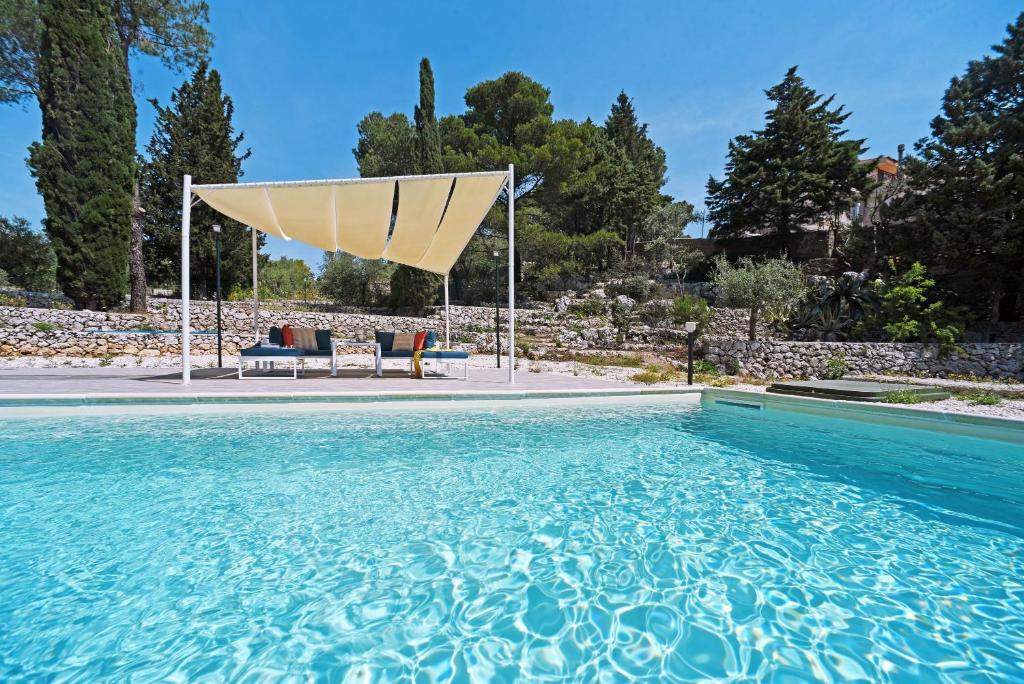 San Corrado di FuoriVilla Pica by PosarelliVillas的一座大型游泳池,上面有一把太阳伞