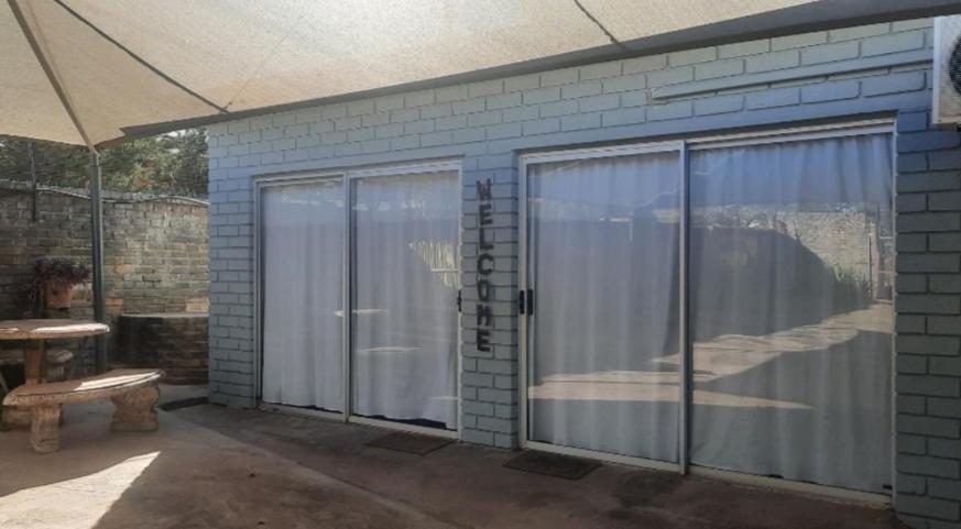 库鲁曼Kalahari Kaja的庭院设有滑动玻璃门和长凳