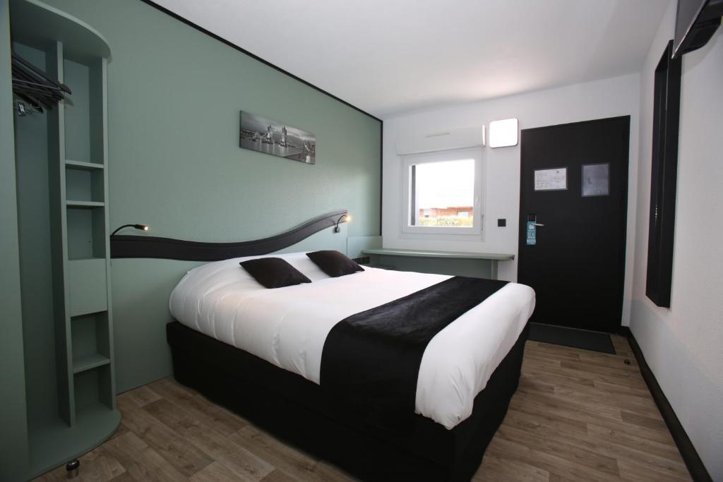 沙特尔Enzo Hotels Chartres Mainvilliers by Kyriad Direct的一间卧室设有一张大床和一个窗户。