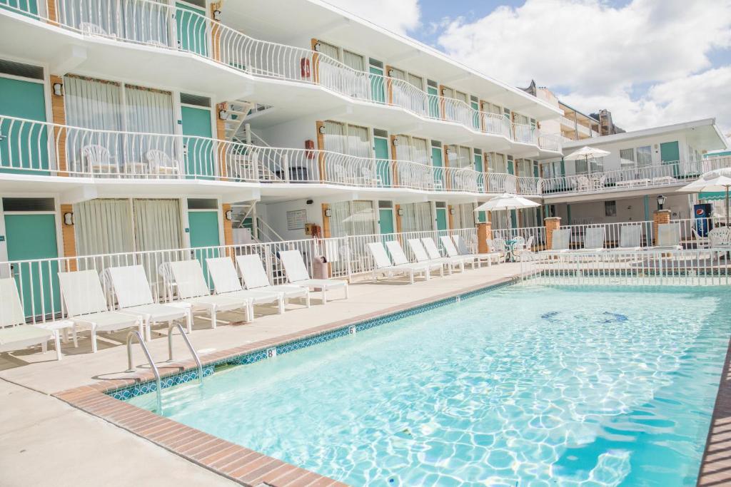 威尔伍德克拉斯特比斯坎家庭度假酒店的一座游泳池位于酒店前,设有椅子和一座建筑