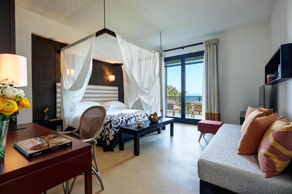 里贝拉维尔杜拉度假酒店的一间卧室配有一张床,客厅配有沙发