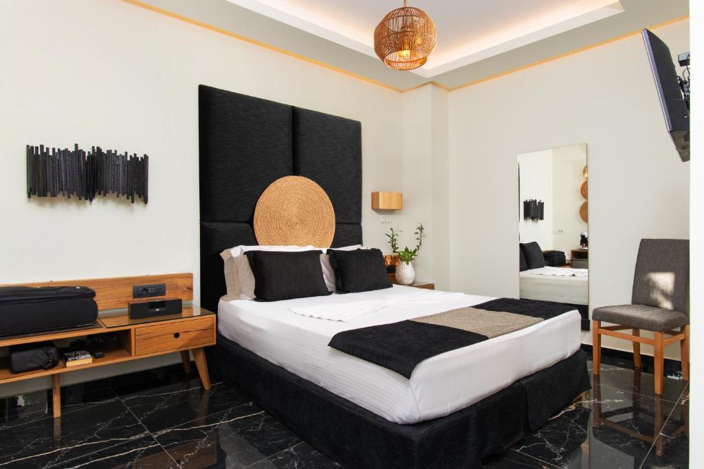 阿达玛斯Angelica's Deluxe Rooms in Adamas的一间卧室配有一张大床和电视