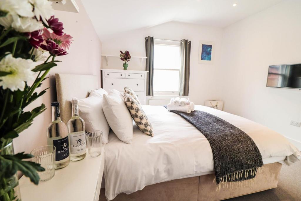 伦敦Modern & spacious 1 bedroom Clapham Junction flat的白色的卧室,配有一张带花瓶的床
