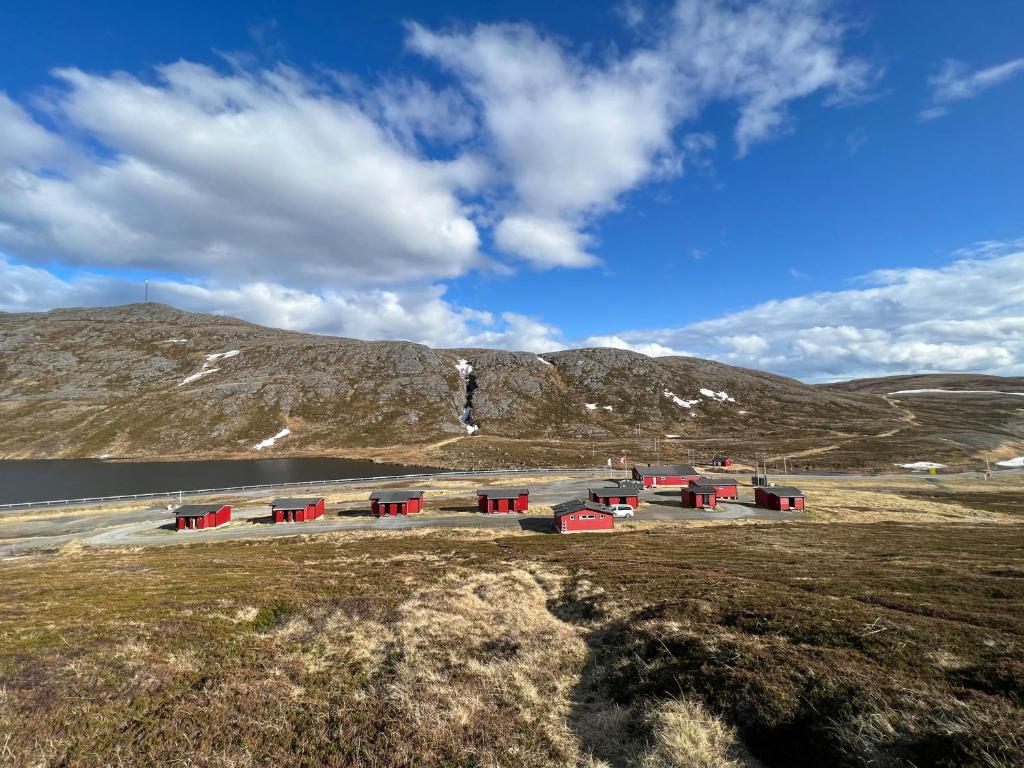 SkarsvågHytte Camp Nordkapp - Red的山边田野上的一群红色建筑