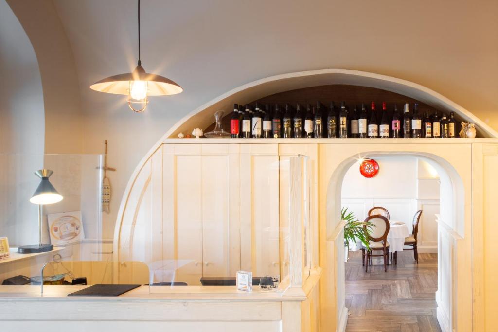 塔兰托Palazzo Matà Boutique Hotel的厨房设有拱门,提供葡萄酒瓶