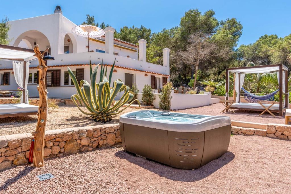 莱斯托伦斯港Sunset Villa Cala Tarida & Cala Comte & Cala Bassa的庭院内带热水浴池的房子