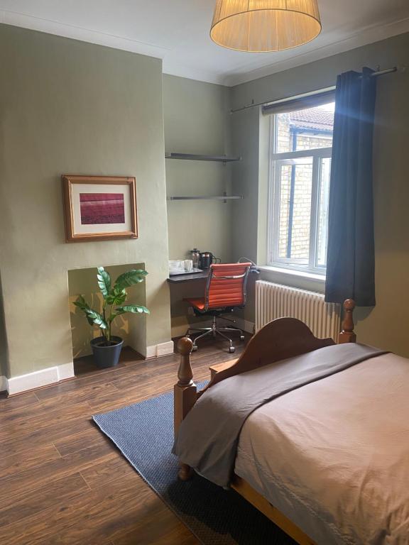 伦敦Tranquil Garden View Double Room的一间卧室配有一张床、一张桌子和一把椅子