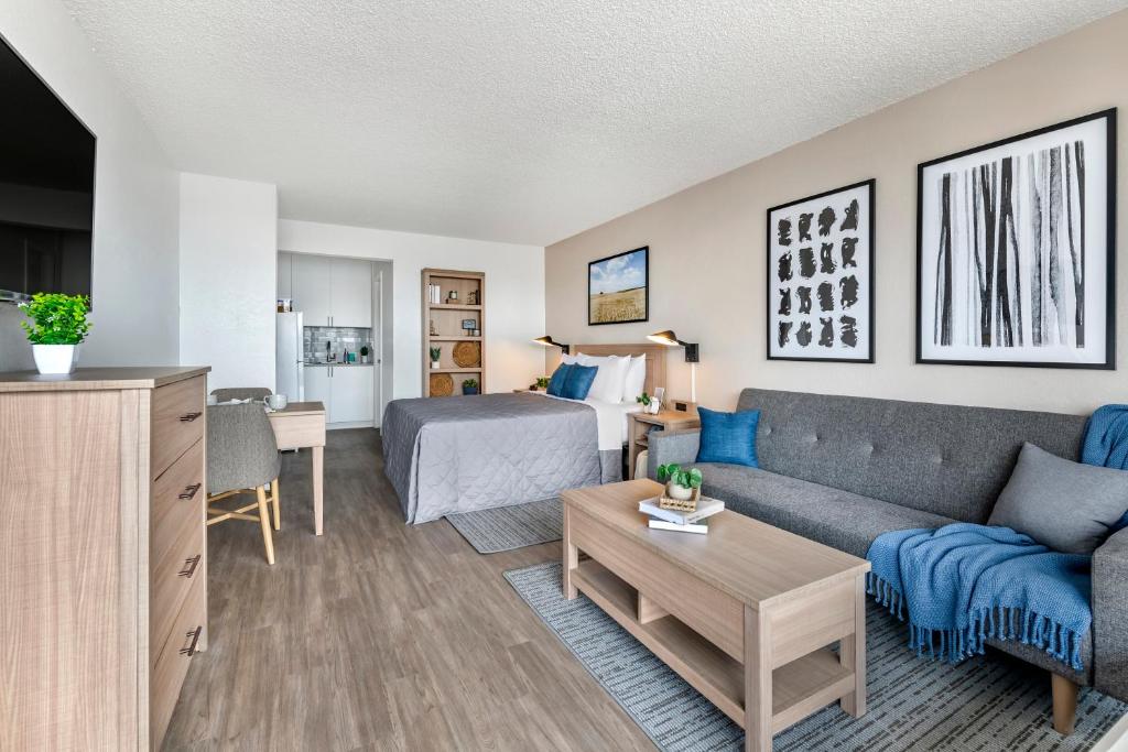 奥兰多InTown Suites Extended Stay Select Orlando FL - Lee Rd的客厅配有沙发和1张床