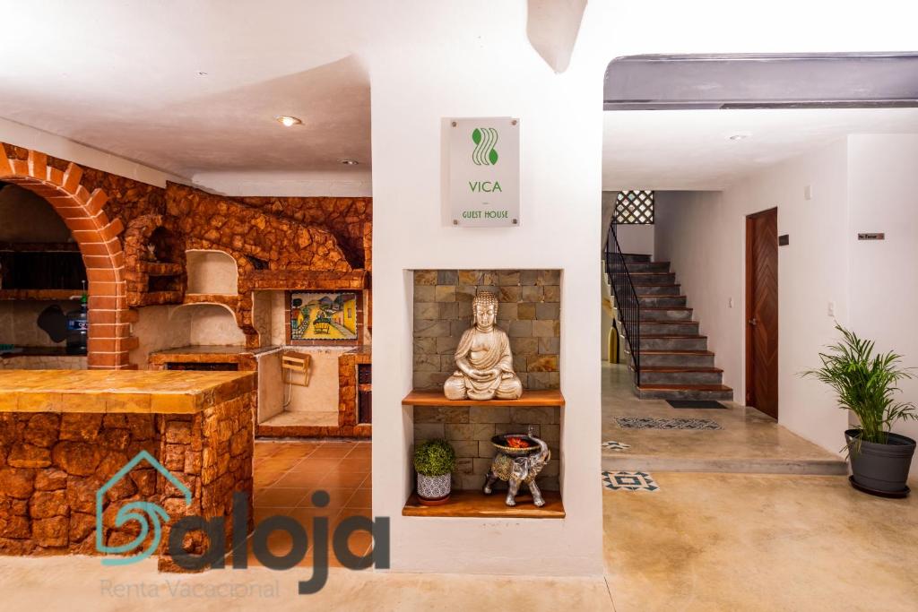 坎昆VIca Guest House con piscina en la entrada de la Zona Hotelera的一间设有佛像和楼梯的房间