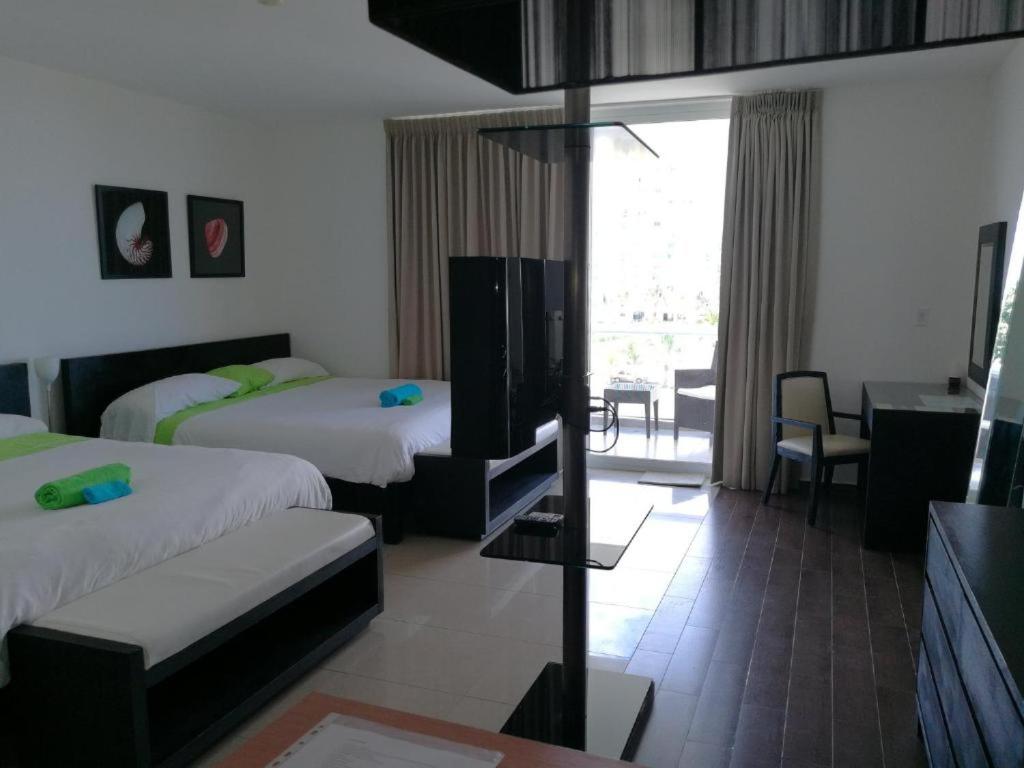 普拉亚布兰卡Playa Blanca的酒店客房配有两张床和一张书桌