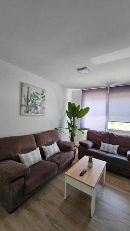 桑蒂蓬塞Apartamento Trajano的客厅配有棕色沙发和茶几