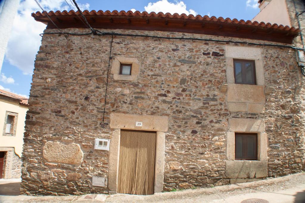 绍塞列vivienda turistica EL PATIO的石头建筑,旁边有一扇门
