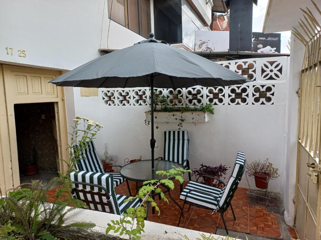 洛哈Villa Amada a place to relax and take a rest的露台配有桌椅和遮阳伞