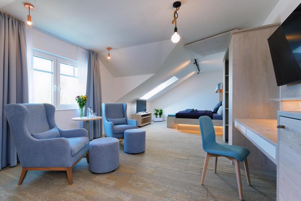 卡罗利嫩西尔施卢伊斯特公园酒店的客厅配有蓝色椅子和沙发