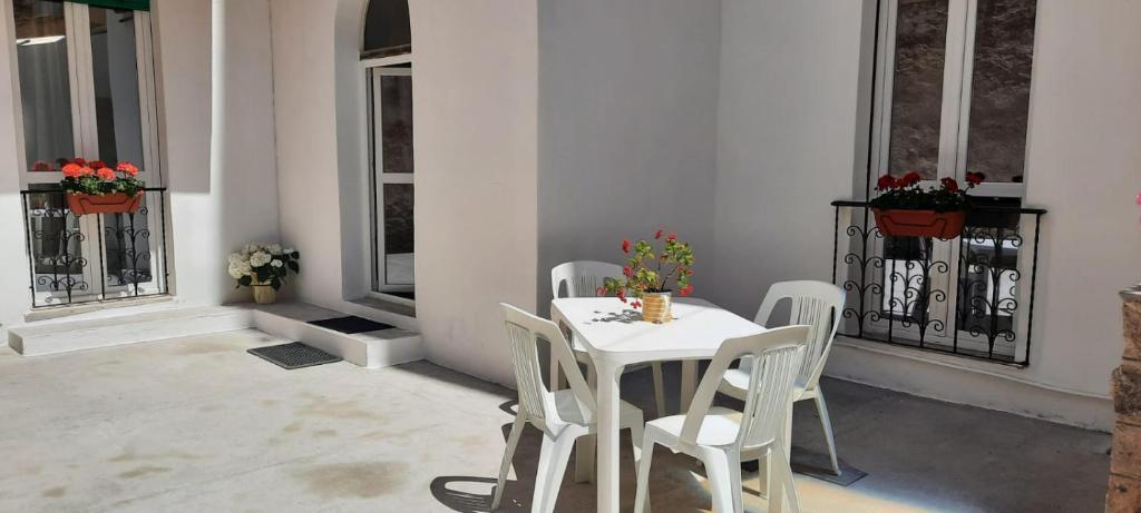 阿尔盖罗La Llua Alghero的窗户客房内的白色桌椅