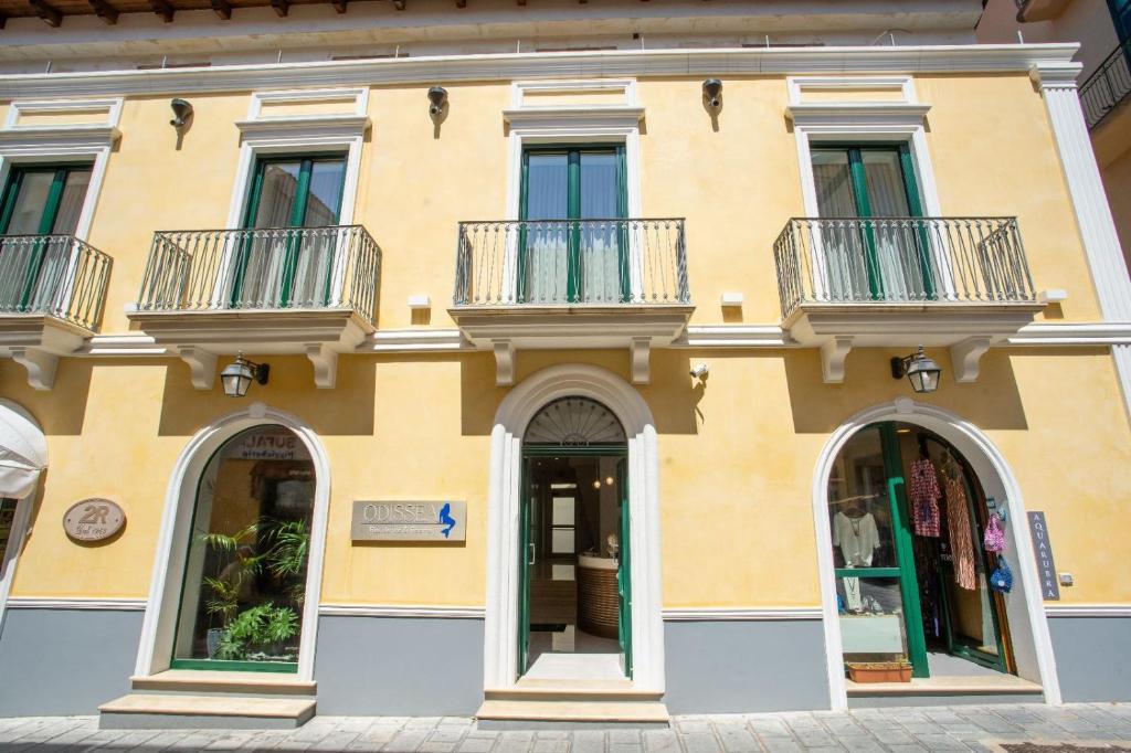 圣塔马里亚迪卡斯特Odissea Residence e Rooms的黄色的建筑,设有两个阳台