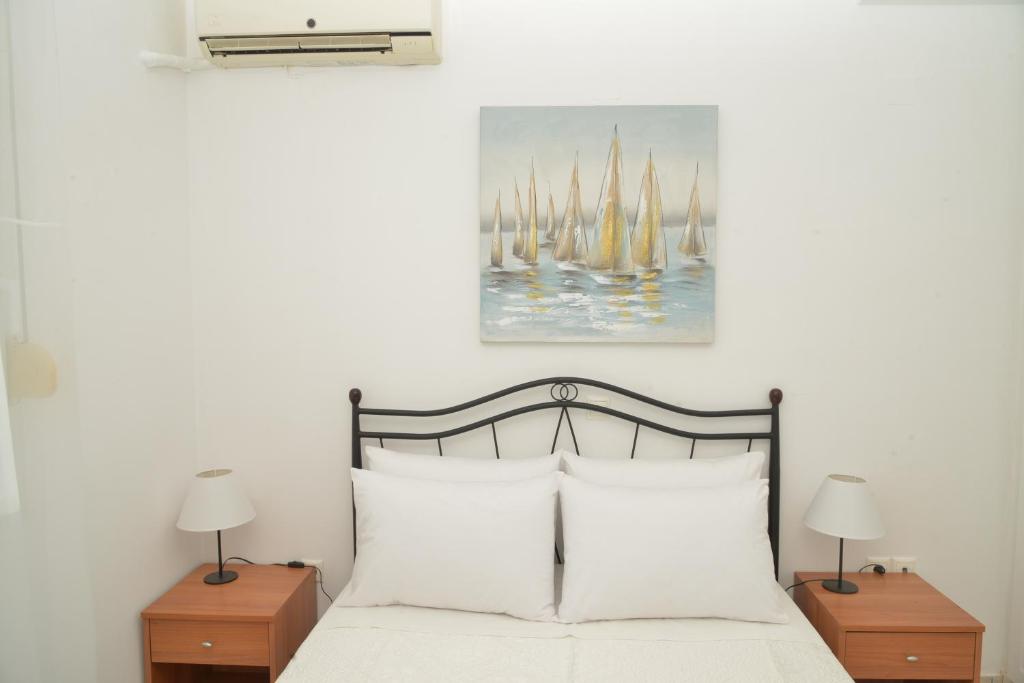 卡诺尼Unique Home的一间卧室配有一张带白色床单和两盏灯的床。