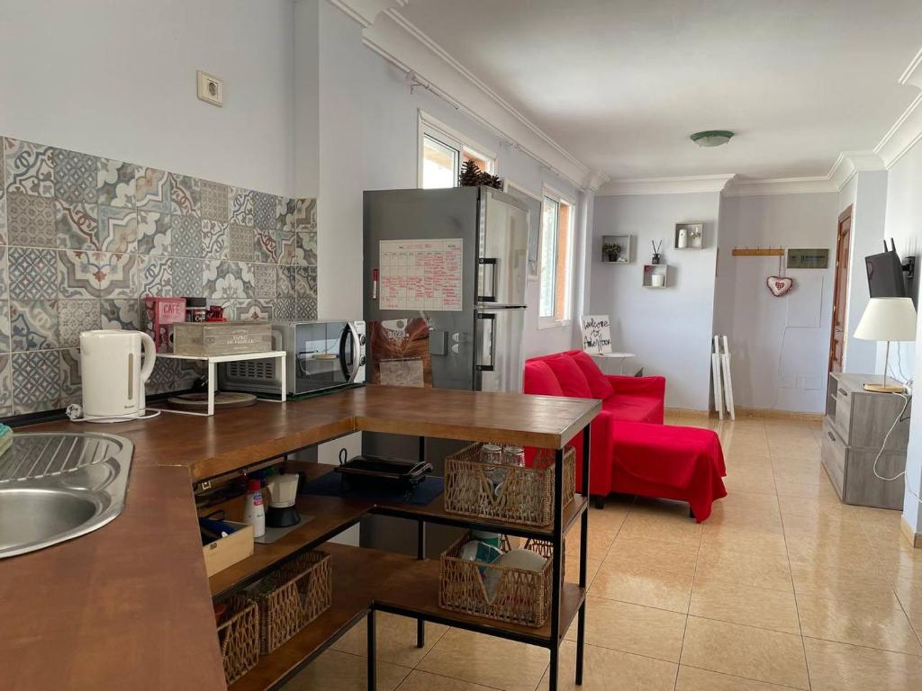 阿里纳加Amber House的一间厨房和一间带红色沙发的客厅