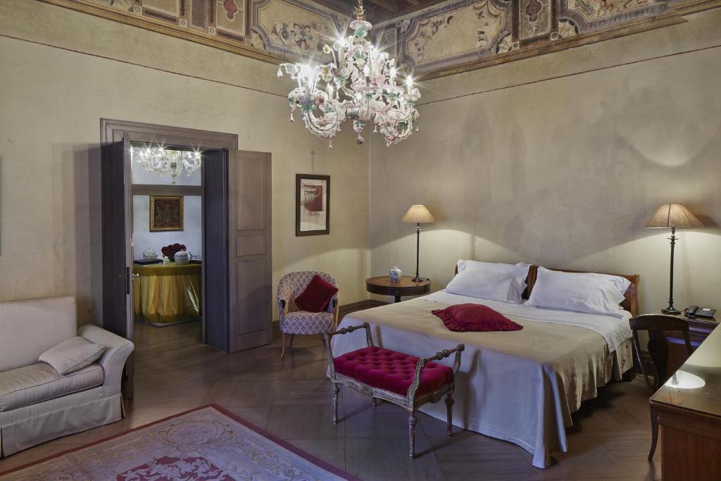 拉文纳凯佩罗酒店的一间卧室配有一张大床和一个吊灯。