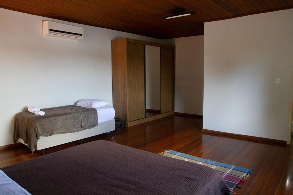 圣湖镇Casa com piscina e churrasqueira em Lagoa Santa MG的一间卧室设有两张床,铺有木地板