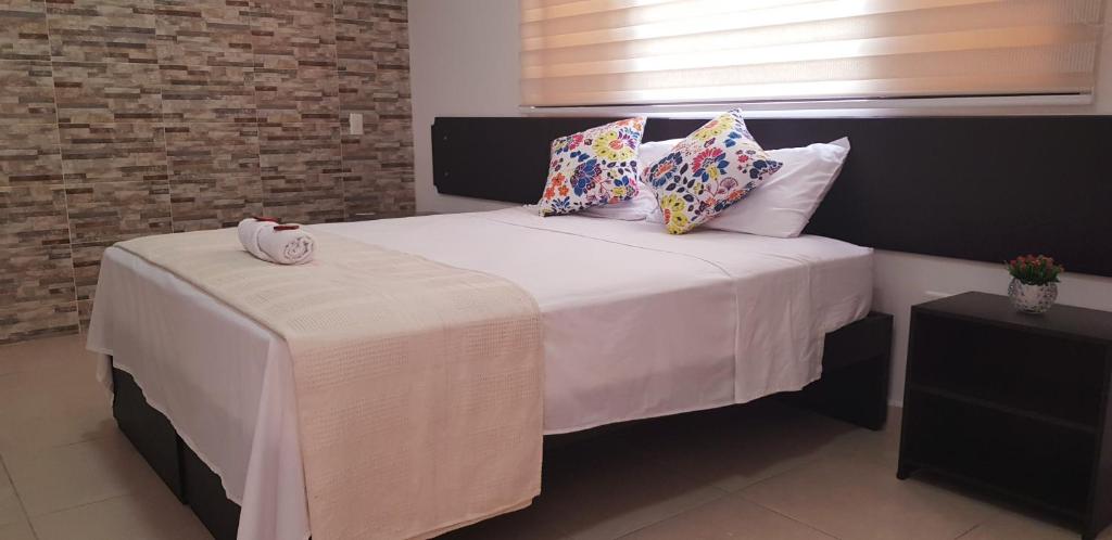圣希尔Aptahotel Guest House的一间卧室配有带白色床单和枕头的床。