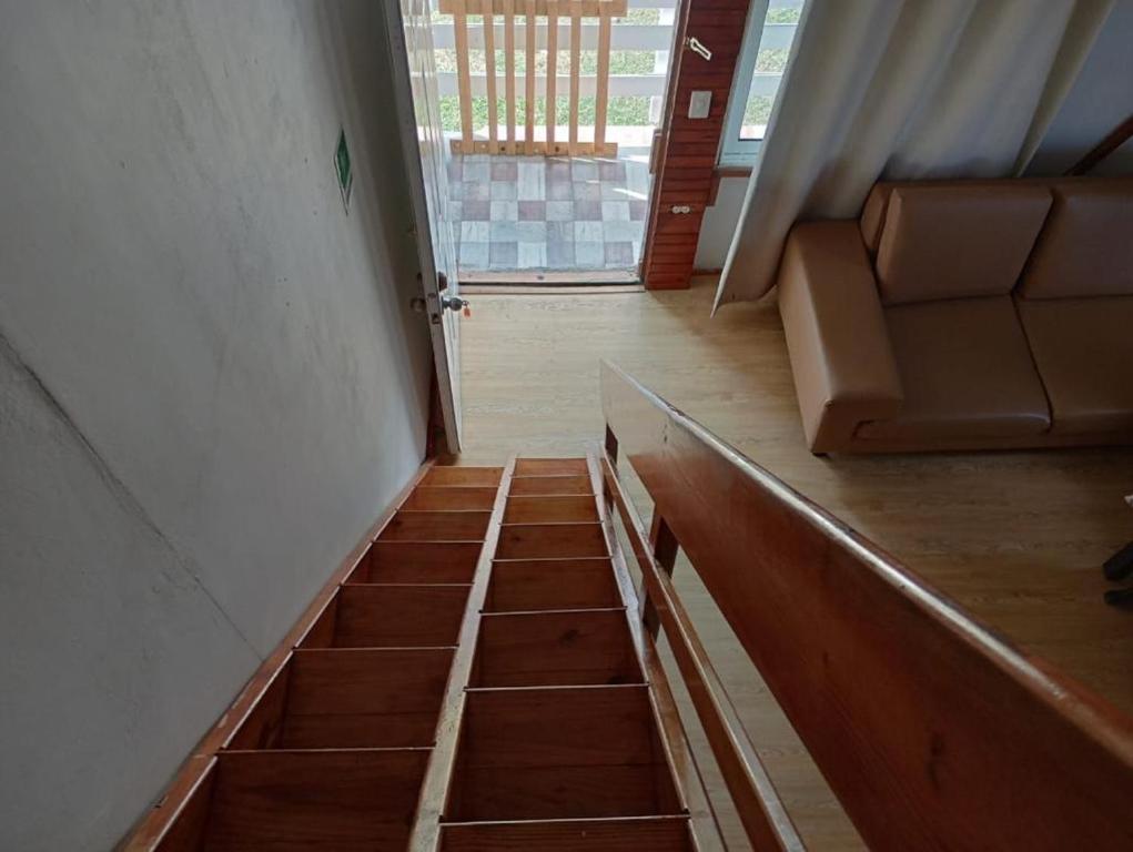 La LomaAPARTAMENTOS CINKEM的客房设有带沙发的楼梯和窗户。