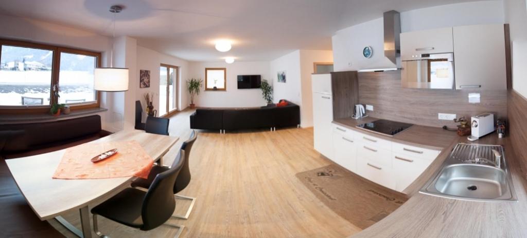 乌登斯多米尼克公寓的厨房以及带桌子和水槽的客厅。