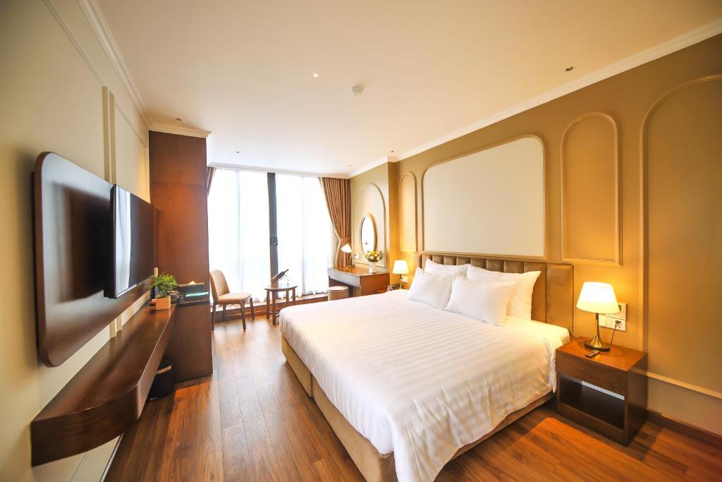 河内L'amant de Hanoi Hotel - khách sạn Lamant de Hà Nội的配有一张床和一台平面电视的酒店客房
