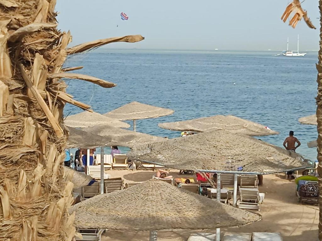 赫尔格达Mashrabeyа Chalet的海滩上设有遮阳伞和椅子,还有大海