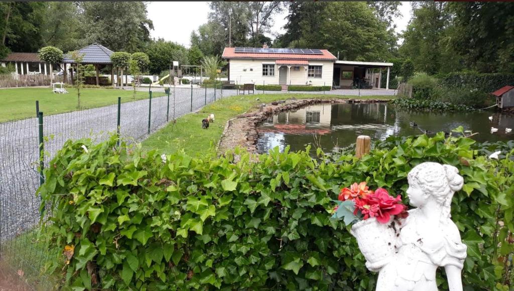 Hechtel-EkselCosy-Cottage的一座公园里一个女孩的雕像和池塘