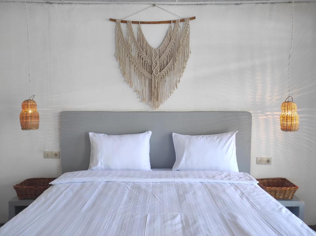 图克图克Hub Tata Guesthouse的卧室配有白色床和2个白色枕头