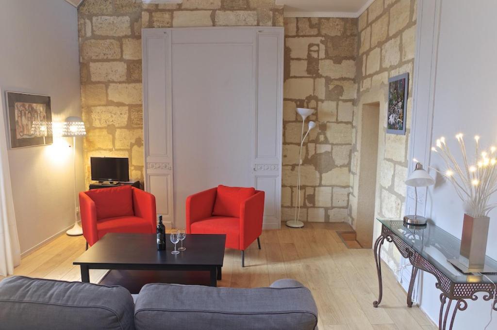 波尔多Chartres - Appartement 1 chambre avec ascenseur的客厅配有2把红色椅子和1张沙发