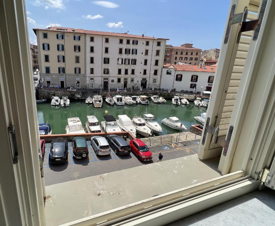 利沃诺La Suite di Chiara的从带船只的码头的窗户欣赏美景
