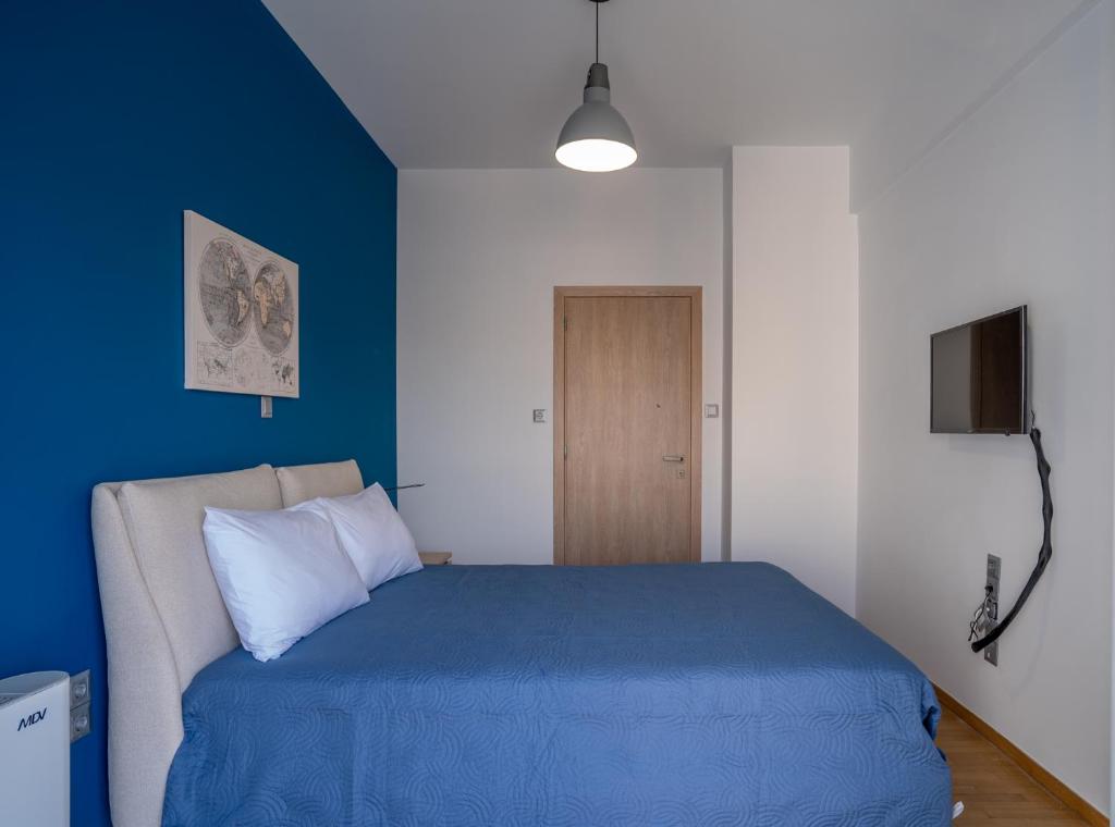 比雷埃夫斯Maxblue 2的一间卧室配有蓝色的床和电视