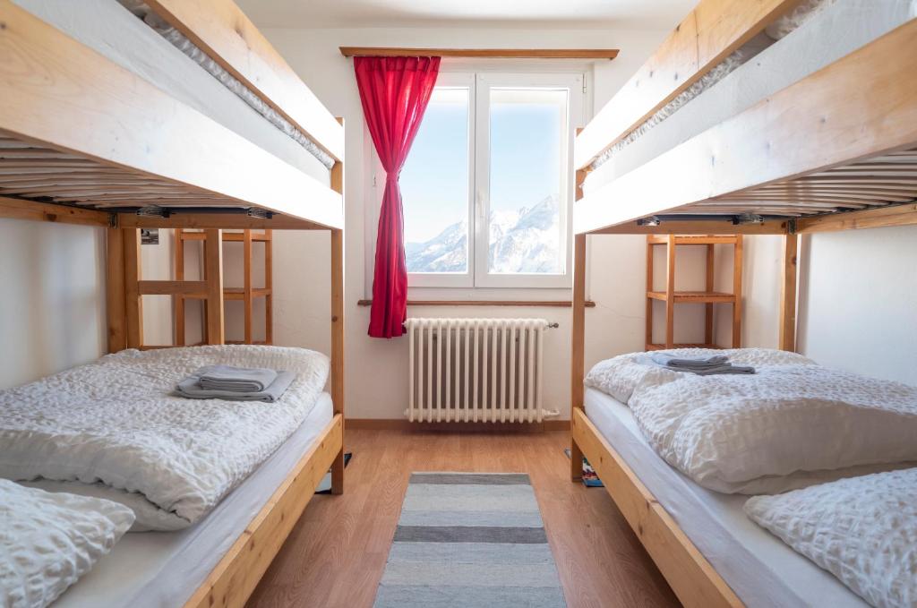 采尔马特施瓦尔茨湖酒店的带窗户的客房内的两张床