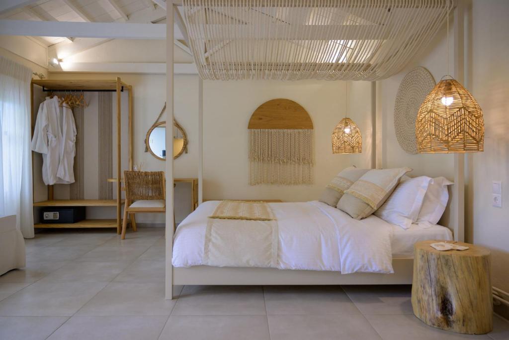 米蒂利尼奥基斯优雅小别墅酒店的卧室配有白色的床,树丛中嵌有树 ⁇ 