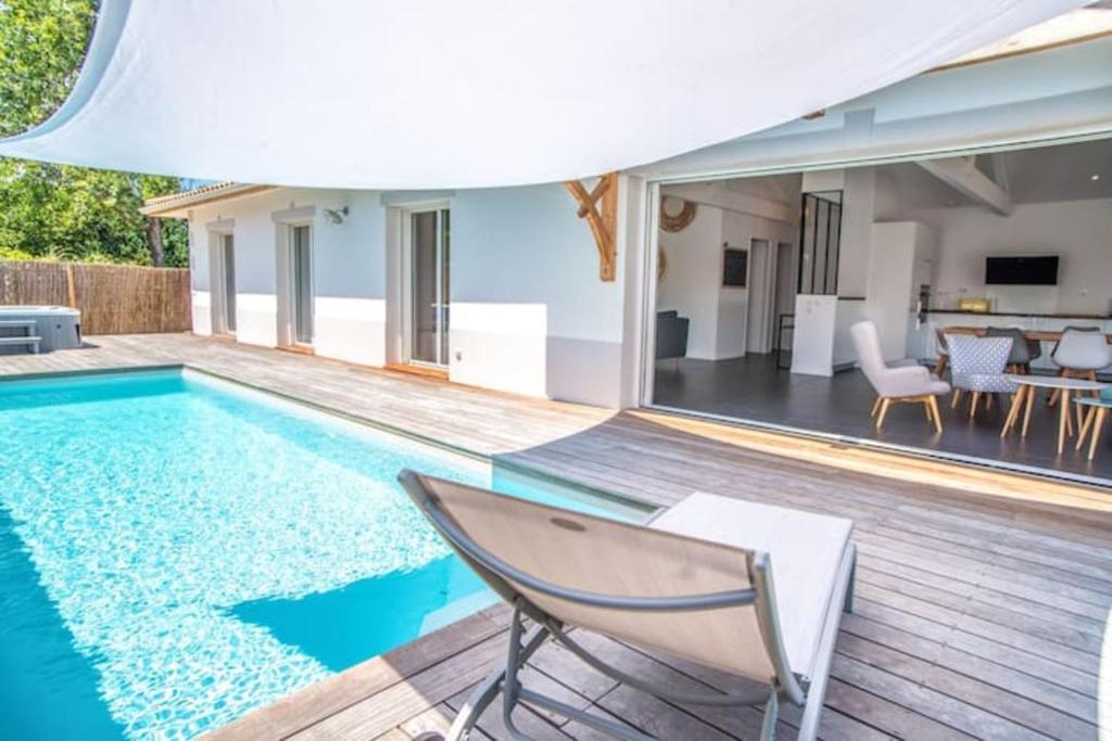 居让梅斯特拉La villa Sirelis piscine et spa的一个带椅子和房子的游泳池