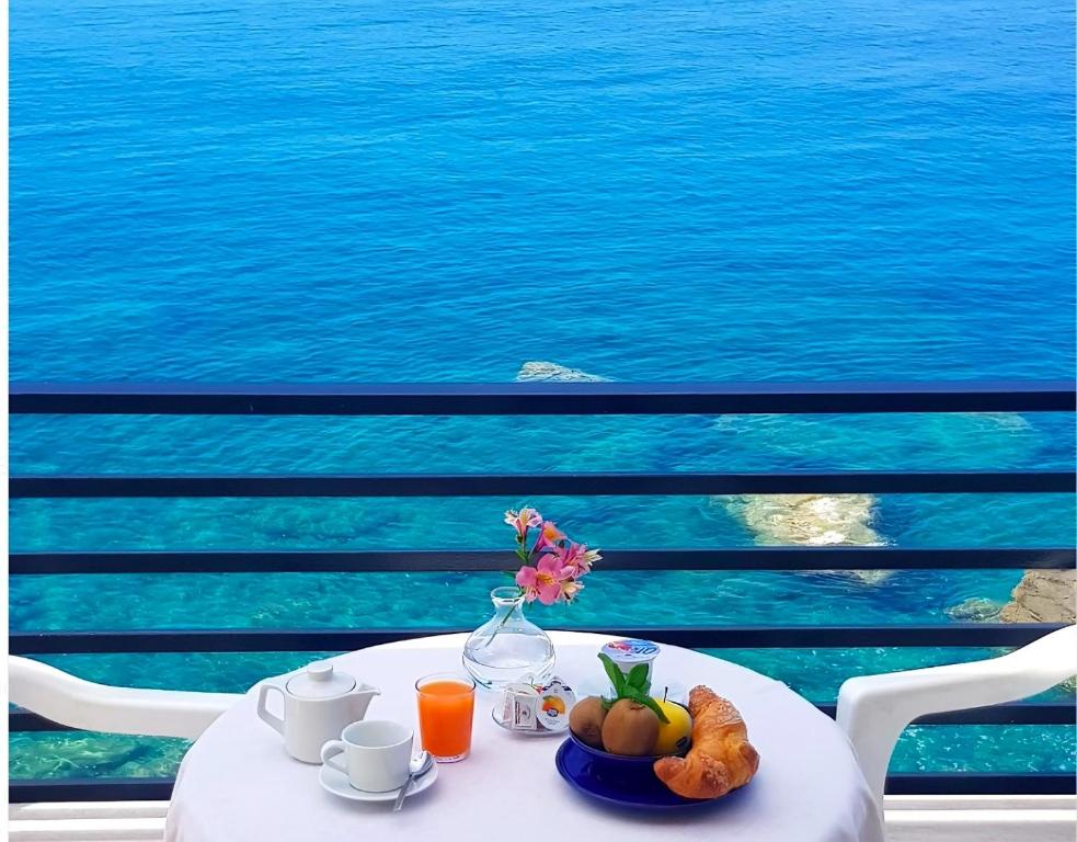 卡迪拉瓦尼亚悬崖酒店的一张带一碗水果和花瓶的白色桌子