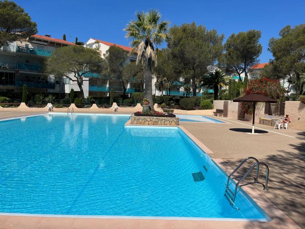 圣拉斐尔Saint-Raphaël, Boulouris, F2 dans belle résidence 3 piscines, proche bord de mer的一个大型蓝色游泳池,后面有棕榈树