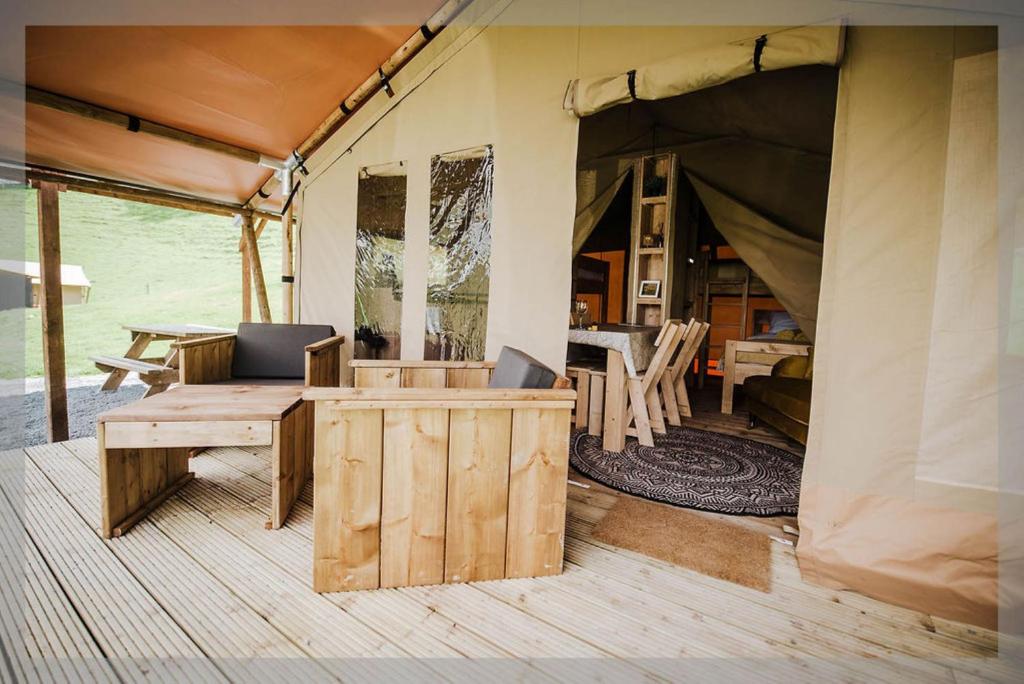 拉尼德洛伊斯Ty Llewelyn Glamping & Camping的带桌椅的帐篷客房