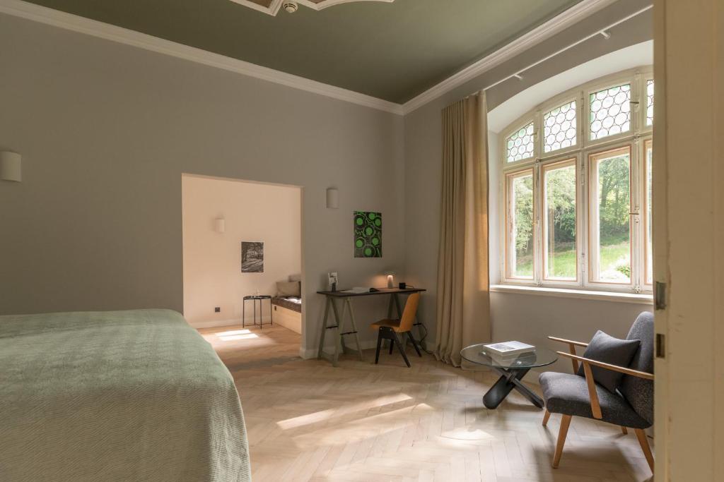 格门德蒂格斯Blyb Hotel的一间卧室配有一张床、一张书桌和一个窗户。