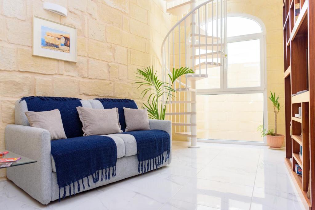 拉巴特Casa Deguara townhouse Rabat Malta的客厅设有蓝色的沙发和窗户。