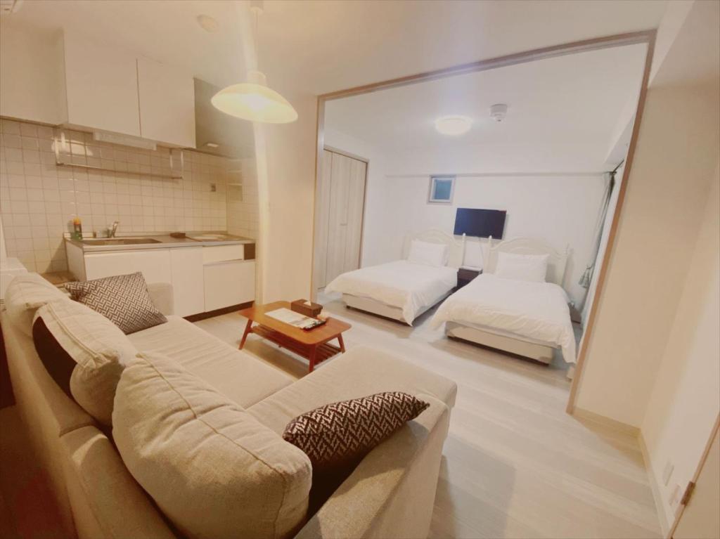 京都Apartment HOTEL KIRO Kyoto STATION的带沙发的客厅和卧室
