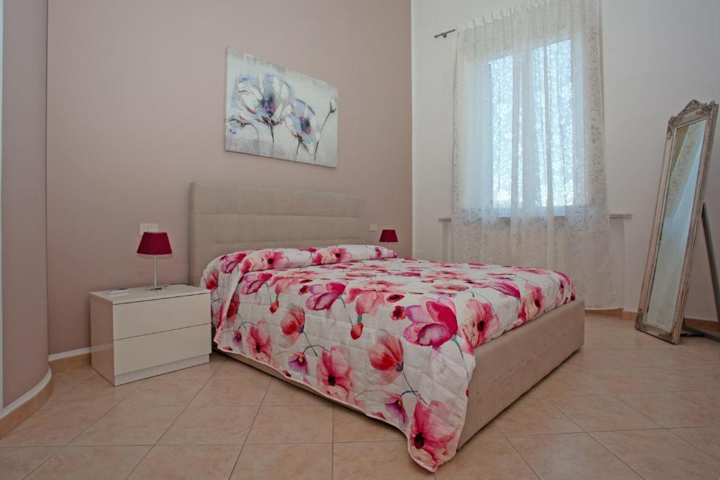 利沃诺Casa Dafne的一间卧室配有一张带红色花卉床罩的床。