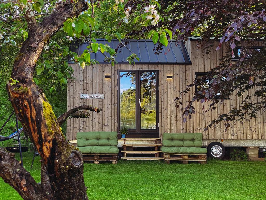 格里姆斯塔Tiny house - idyllic accommodation的院子里两把绿色椅子的房子