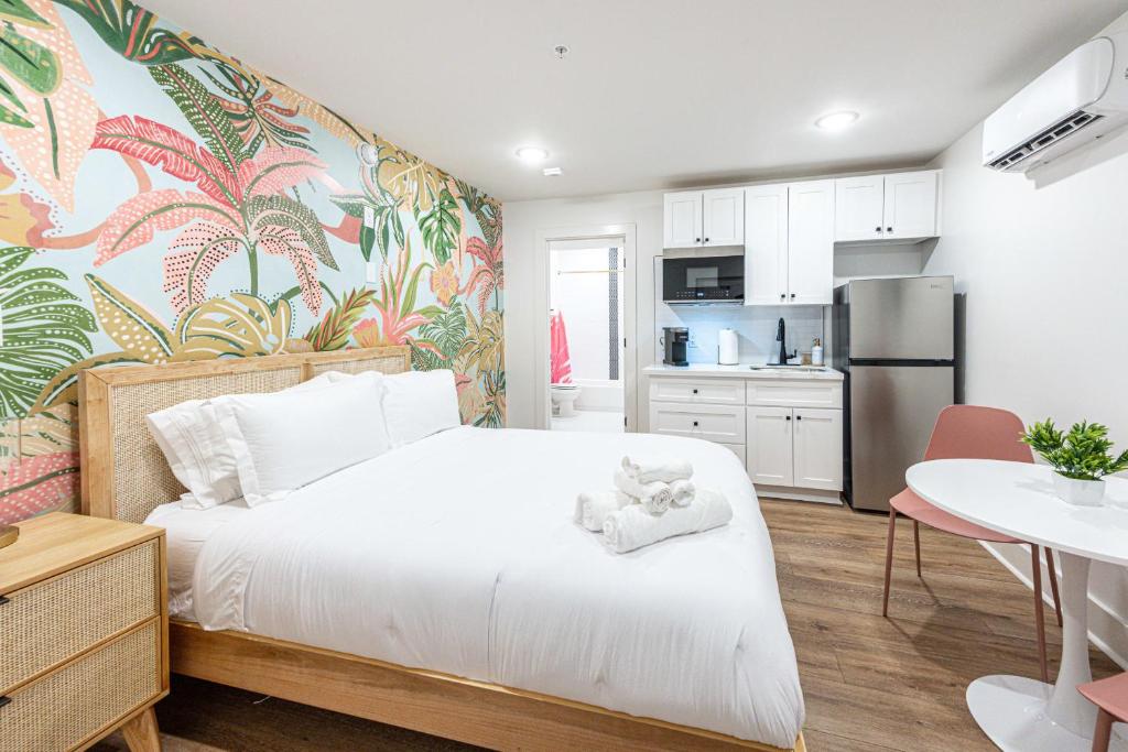 加尔维斯敦Pastel Tropics Studio Apartment的一间带白色床的卧室和一间厨房
